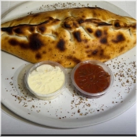 Dichtgevouwen pizza met kaas, shoarma, paprika, ui en champignons